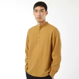 Camisa color mostaza de manga larga con cuello mao y cierre parcial con botones.
