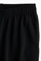 Pantalón negro de corte recto y cintura elástica.