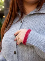 Cárdigan marrón de tejido con relieve, cuello camisero con borde celeste, cierre frontal con botones y calce relajado.