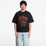 Camiseta negra de manga corta con cuello redondo. Presenta un estampado frontal en color rojo con tipografía gótica que dice "Carhartt" y debajo tres figuras estilizadas, con el texto "Detroit, Mich." en la parte inferior.