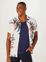 Camisa blanca de manga corta con estampado de hojas en negro y gris, cuello clásico y corte recto.