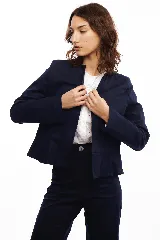 Chaqueta azul marino con cuello mao, volado en el bajo y solapas opcionales.
