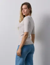 Remera color beige de corte ajustado, con cuello redondo y mangas cortas. Tejido acanalado de modal y elastano.