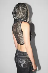 Top negro de tejido con transparencias, cuello alto y capucha. Sin mangas y corte ajustado al cuerpo.