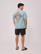 Remera de algodón con lavado, color celeste verdoso, de corte holgado (loose fit) y cuello redondo. Presenta un pequeño estampado gráfico en el pecho.