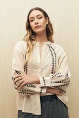 Camisa gris oscuro con estampado de triángulos blancos en el frente, mangas y cuello.