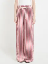 Pantalón de viscosa con rayas verticales rojas y blancas, corte recto, cintura elástica con cordón decorativo.
