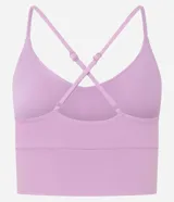 Top deportivo color rosado claro, con breteles finos ajustables que forman una X en la espalda. Presenta una banda ancha bajo el busto y un detalle de corte (cutout) en la parte delantera del busto.