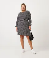 Vestido corto de viscosa con estampado de corazones, cuello redondo, manga larga, elástico en la cintura y botón en el puño.