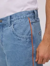 Bermuda de jean celeste con detalle de una línea vertical naranja en los laterales.