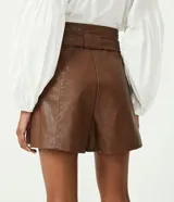 Short marrón de cuero sintético, tiro alto, corte clochard, con cinturón con hebilla metálica.