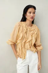 Camisa negra de tencel liviana con volados románticos y manga corta.