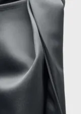 Vestido corto gris de tejido satinado con detalle de nudo en el hombro.