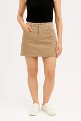 Minifalda color beige de jean con tiro alto y corte al cuerpo.