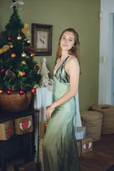 Vestido largo color marrón cobrizo con escote en V, cut outs laterales bajo el busto y breteles finos que se cruzan y atan en la espalda. Presenta un top con estampado abstracto en tonos marrones y dorados.