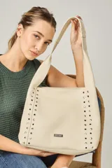 Cartera tipo shopper color negro, con apliques de tachas plateadas en los laterales y logo de la marca en la parte inferior.