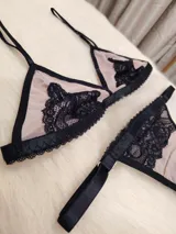 Conjunto de lencería de microtul color tostado con detalles de encaje negro. Incluye corpiño triangular con breteles finos regulables y tanga regulable de elástico ancho.