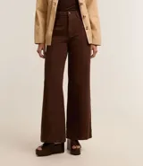 Pantalón wide leg color crudo, de sarga con tiro alto, trabillas, bolsillos delanteros y traseros, y costura vertical delantera.