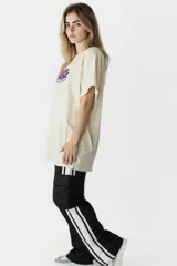 Remera beige con estampado de frutas y texto en azul.