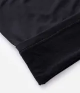 Remera deportiva térmica de manga larga para hombre, color negro, con cuello alto y cierre frontal parcial. Presenta recortes en los hombros y mangas raglán.