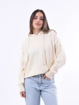 Canguro de tejido punto color crudo, con capucha y cordones ajustables. Presenta puños y cintura acanalados.