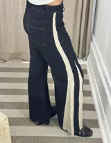 Pantalón ancho de jean celeste con paneles laterales en tela color camel con estampado sutil.