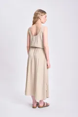 Vestido midi color beige, sin mangas, con corte a la cintura con elástico.