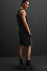 Bermuda jogger negra confeccionada en tejido de algodón con interior de rizo, cintura elástica ajustable con cordón y bolsillos laterales.