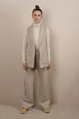 Chaleco color beige, entallado, con solapa, bolsillos plaqué y terminaciones envivadas.