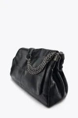 Bolso de hombro marrón oscuro de cuero sintético, con solapa y cierre magnético. Tiene un asa de cadena plateada y tres compartimentos internos, uno de ellos con cierre de cremallera.