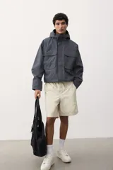 Short color crema de lona de algodón suave, con cintura elástica con cordón para ajustar, bolsillos al bies y un bolsillo insertado atrás. Corte estándar.