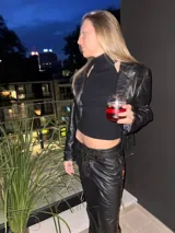 Campera corta de cuero negro, estilo torera, con animal print y flecos en la espalda.