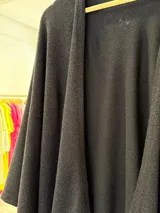 Ruana gris de tejido de punto con caída irregular.