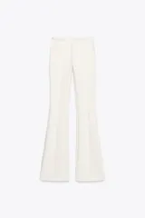 Pantalón blanco de tiro alto confeccionado en tejido de punto elástico y flexible con trama compacta, mullida y opaca. Bajo acampanado.