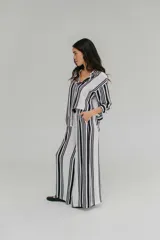 Pantalón blanco con rayas verticales negras, de tiro alto y corte palazzo.