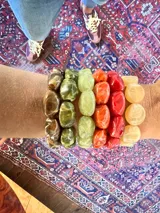 Set de pulseras elásticas con cuentas de piedra en tonos amarillo, naranja, rojo, verde y marrón.