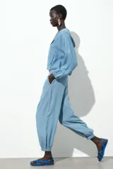 Pantalón jogger celeste confeccionado en lino, con tiro alto, cintura elástica ajustable con cordón, bolsillos delanteros y puños elásticos en el bajo.