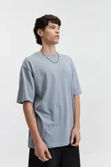 Remera de manga corta color marrón claro, de corte amplio y cuello redondo.