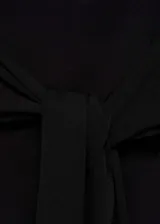 Top bandeau negro de punto fino con detalle de nudo en la cintura y diseño entallado.