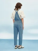 Mono largo de denim celeste con breteles regulables y lazo en la cintura.