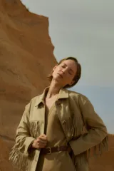 Chaqueta color beige de simil gamuza con flecos en el frente y en la espalda.