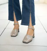 Zapato de cuero vacuno color negro con textura croco, con talón cubierto, pulsera con hebilla y taco de madera forrado en cuero.