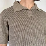 Chomba de punto color marrón con cuello polo y mangas cortas.