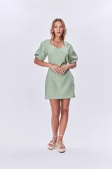 Vestido corto verde de lino, con escote cuadrado, mangas abullonadas cortas y corte recto.