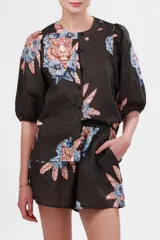 Camisa de manga corta abullonada con cuello mao y estampado de tigres y flores en tonos naranja, azul y rosa sobre fondo gris.