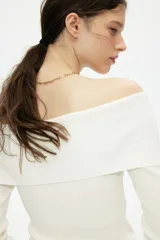 Top blanco de manga larga en tejido de punto acanalado, con escote Bardot (hombros descubiertos) y borde doblado.