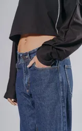 Pantalón de denim azul con cinco bolsillos y corte wide leg.