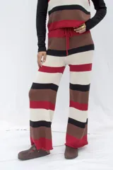 Pantalón tejido artesanalmente a rayas horizontales en tonos marrón, beige, negro y rojo.