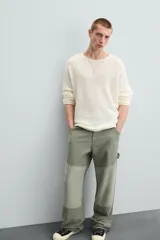 Pantalón de jean color verde con diseño de bloques de color en diferentes tonos de verde, corte amplio, tiro alto, cinco bolsillos y presilla para herramientas en la pierna.