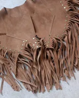 Chaleco marrón de cuero gamuzado con flecos y tachas doradas.